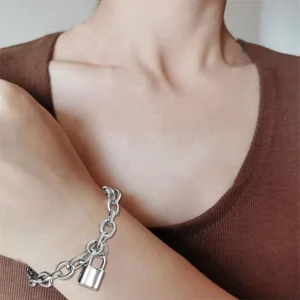 Femme portant un Bracelet Chaîne Rolo en Acier Inoxydable avec Pendentif Cadenas.