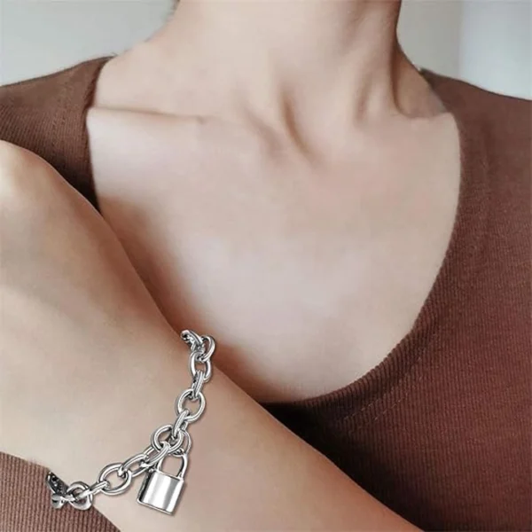 Femme portant un Bracelet Chaîne Rolo en Acier Inoxydable avec Pendentif Cadenas Femme portant un Bracelet Chaîne Rolo en Acier Inoxydable avec Pendentif Cadenas.