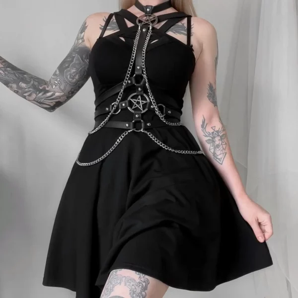 Femme portant un Harnais Sangles Cuir avec Chaînes et Pentacles Métalliques sur une robe Femme portant un Harnais Sangles Cuir avec Chaînes et Pentacles Métalliques sur une robe.