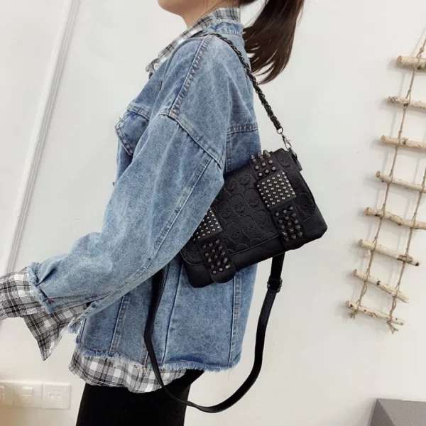 Femme portant un Sac Bandoulière en Cuir Noir avec Rivets & Motif Têtes de Mort Femme portant un Sac Bandoulière en Cuir Noir avec Rivets & Motif Têtes de Mort.