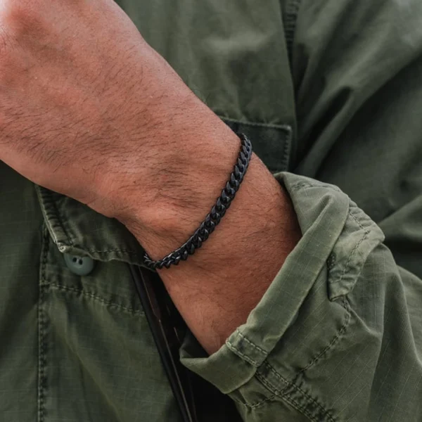 Homme portant un Bracelet Gourmette à Maille Cubaine en Acier Noir PVD 7 mm Homme portant un Bracelet Gourmette à Maille Cubaine en Acier Noir PVD 7 mm.