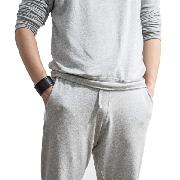 Homme portant un Bracelet Large en Similicuir Noir à Rainures Latérales Homme portant un Bracelet Large en Similicuir Noir à Rainures Latérales.