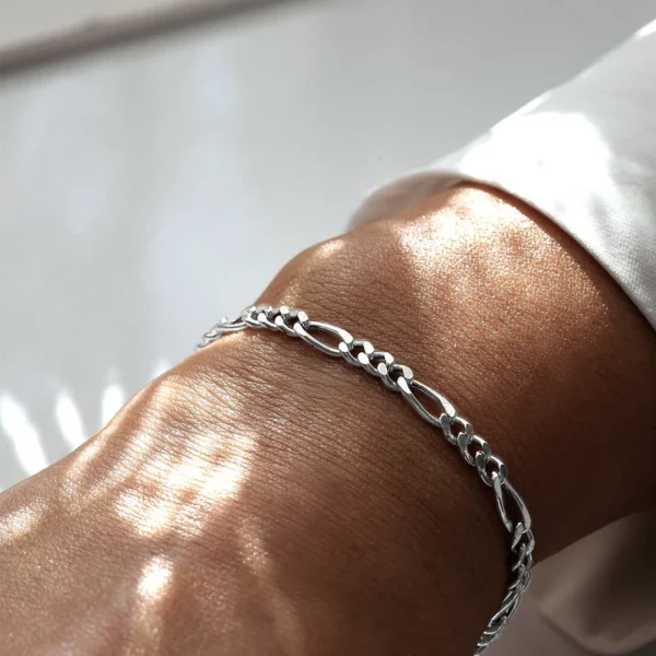 Homme portant un Bracelet à Maille Figaro Acier Inoxydable - 6 mm Homme portant un Bracelet à Maille Figaro Acier Inoxydable - 6 mm.