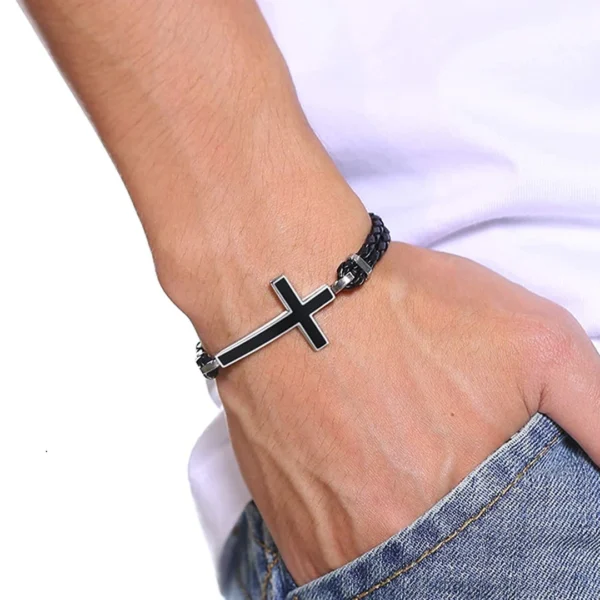 Homme portant un Bracelet en Cuir Tressé & Croix Acier Noir Onyx Homme portant un Bracelet en Cuir Tressé & Croix Acier Noir Onyx.