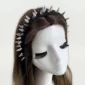 Modèle Féminin avec un Serre-Tête Clouté en Tissu Noir.
