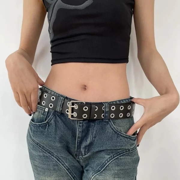 Modèle Féminin portant une Ceinture en Cuir Noir avec Double Rangée d’Œillets Métalliques Modèle Féminin portant une Ceinture en Cuir Noir avec Double Rangée d’Œillets Métalliques.