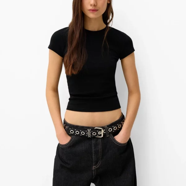 Modèle Féminin portant une Ceinture en Cuir Noir avec Œillets Métalliques Modèle Féminin portant une Ceinture en Cuir Noir avec Œillets Métalliques.