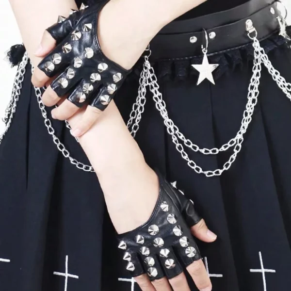 Modèle féminin portant des mitaines en cuir cloutées au style gothique Modèle féminin portant des mitaines en cuir cloutées au style gothique.