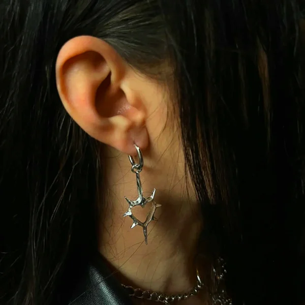 Femme Gothique Punk portant des Créoles à Cœur Épineux Suspendu en Acier Femme Gothique Punk portant des Créoles à Cœur Épineux Suspendu en Acier.