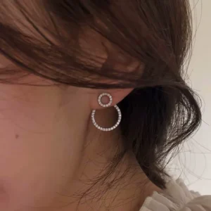 Femme avec Boucles d'Oreilles Double Cercle Flottant Pavé Zirconiums.
