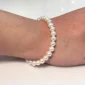 Femme avec Bracelet de Perles Blanches 8 mm.