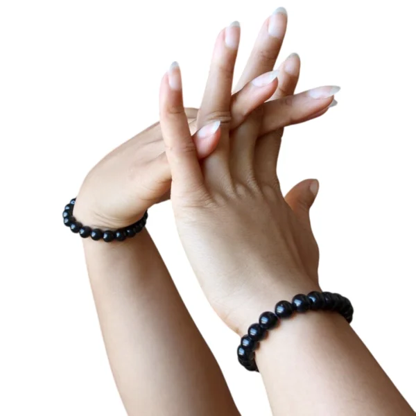 Femme avec Bracelet de Perles Noires 8 mm au Poignet Femme avec Bracelet de Perles Noires 8 mm au Poignet.