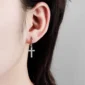 Femme avec Créoles Croix Pendante Pavée de Zirconiums en Argent 925.