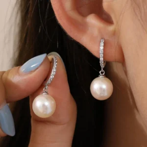 Femme avec Créoles Élégantes Perles Argent 925 et Zirconiums.