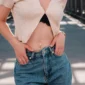 Femme avec Piercing Nombril Banane Inversée à Croix Pavée Zirconiums.