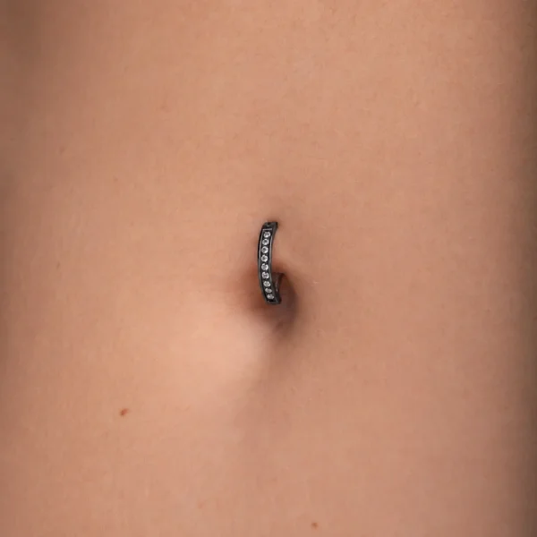 Femme avec Piercing Nombril Clicker Titane Noir à Zircons Sertis Femme avec Piercing Nombril Clicker Titane Noir à Zircons Sertis.
