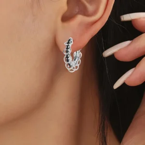 Femme avec des Créoles Argent 925 à Pavage Zircons Noirs et Anneaux Mobiles.