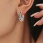 Femme avec des Créoles Argent 925 à Pavage Zircons Noirs et Anneaux Mobiles.