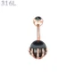 Piercing Nombril Sphère Noire Sertie d’une Main Squelettique Acier 316L Or Rose PVD.