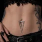 Femme Gothique avec Piercing Nombril Chandelier Floral à Chaînes et Zirconiums.