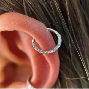 Femme avec Anneau Charnière Titane à Arc Pavé de Zirconiums sur l'Hélix (cartilage).