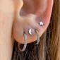 Femme avec Piercing Clicker 8 mm et 10 mm en Titane à Tranche Pavée de Zirconiums au Lobe et 2e Lobe d'Oreille.