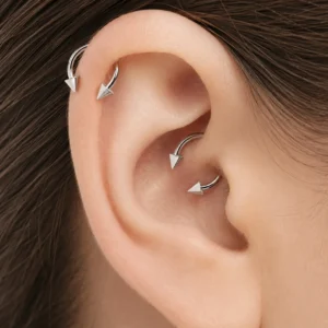 Femme avec Piercing Fer à Cheval à Pointes Coniques Titane à l’Hélix et au Daith Femme avec Piercing Fer à Cheval à Pointes Coniques Titane à l'Hélix et au Daith.