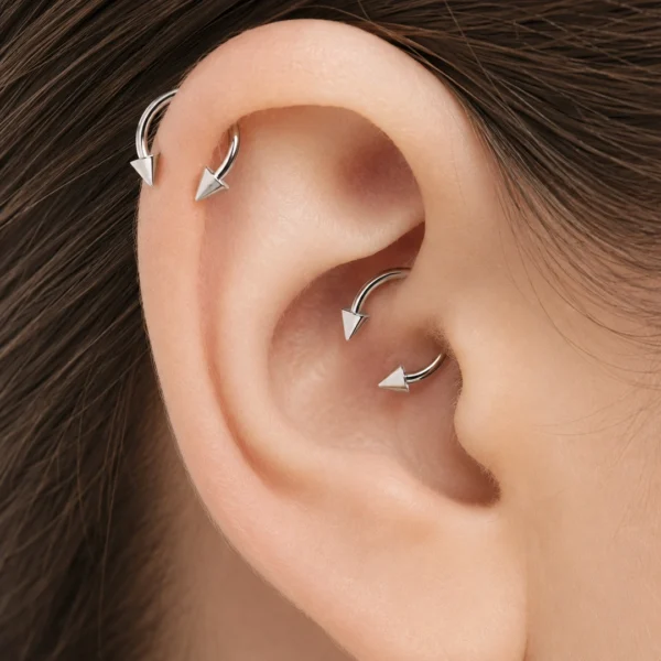 Femme avec Piercing Fer à Cheval à Pointes Coniques Titane à l'Hélix et au Daith Femme avec Piercing Fer à Cheval à Pointes Coniques Titane à l'Hélix et au Daith.
