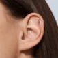 Femme avec Piercing Labret Titane Zirconium & Pointe Suspendue à l'Oreille (Cartilage Hélix).