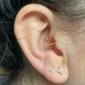 Femme avec un Piercing Cœur en Titane Anodisé Doré à l'Oreille (Daith).