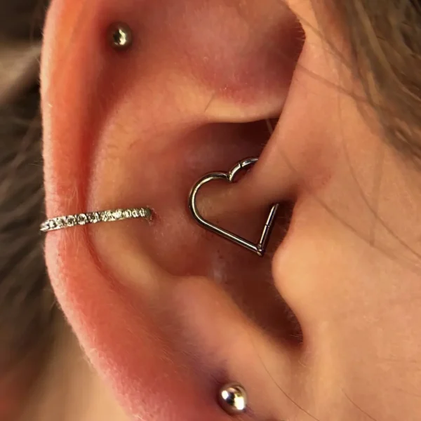 Femme portant un Piercing Cœur Clicker en Titane au Daith Femme portant un Piercing Cœur Clicker en Titane au Daith.