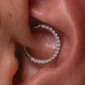 Piercing Anneau Charnière Titane à Arc Pavé de Zirconiums au Daith.