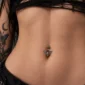Femme Gothique avec Piercing Nombril Tête de Mort Ailée aux Yeux Zirconiums.