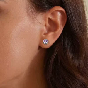 Femme avec Boucles d’Oreilles Crâne Phosphorescent en Argent 925.