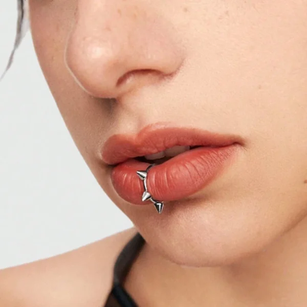 Femme avec Faux Piercing Anneau à Pointes sur la Lèvre Inférieure (labret vertical) Femme avec Faux Piercing Anneau à Pointes sur la Lèvre Inférieure (labret vertical).