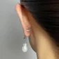 Femme avec Fermoirs de Boucles d’Oreilles en Acier & Silicone.