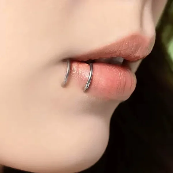 Femme avec un Faux Piercing Double Anneau en Acier 316L à la Lèvre Femme avec un Faux Piercing Double Anneau en Acier 316L à la Lèvre.