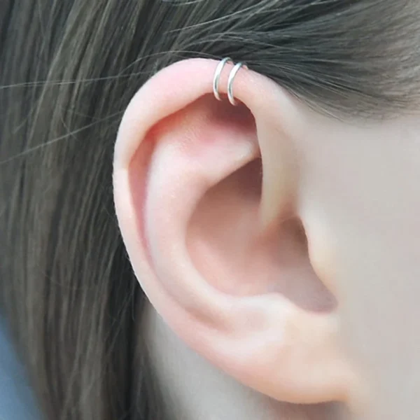 Femme portant un Faux Piercing Double Anneau en Acier 316L au Cartilage (Hélix) Femme portant un Faux Piercing Double Anneau en Acier 316L au Cartilage (Hélix).