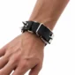 Homme avec Bracelet en Cuir Noir Clouté et Fermeture Boucle Ardillon.