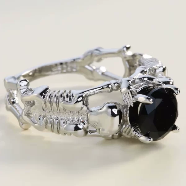 Bague Gothique Squelettes Prosternés en Argent 925 avec Zircon Noir (vue de côté) Bague Gothique Squelettes Prosternés en Argent 925 avec Zircon Noir (vue de côté).
