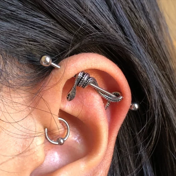 Femme portant un Piercing Industriel Orné d'un Serpent en Acier Chirurgical Femme portant un Piercing Industriel Orné d'un Serpent en Acier Chirurgical.