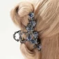 Femme avec une Pince à Cheveux Fleurs de Camélia Bleutées en Acier.