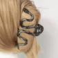 Femme avec une Pince à Cheveux Serpent en Acier Noir.