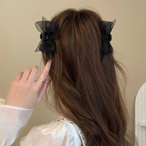 Femme coiffée de Pinces Crabe avec Nœuds Papillon en Organza Noir.