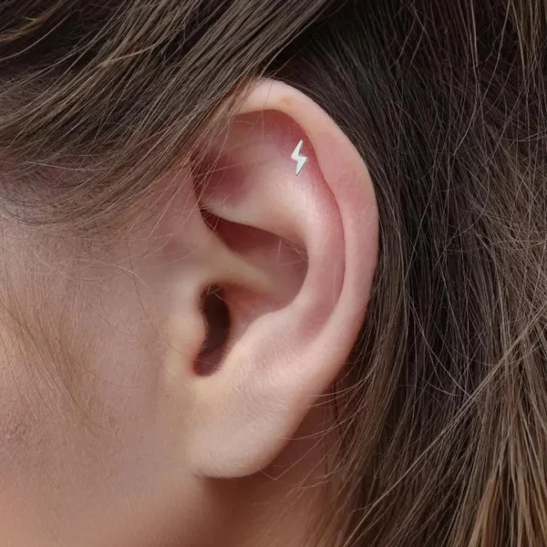 Femme portant un Piercing Labret Éclair Titane à l'hélix.