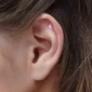 Femme portant un Piercing Labret Éclair Titane à l'hélix