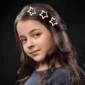 Fille avec des Barrettes Étoile en Acier dans les Cheveux.