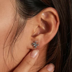 Femme portant des Clous d’Oreilles Araignée en Argent 925 Sterling.