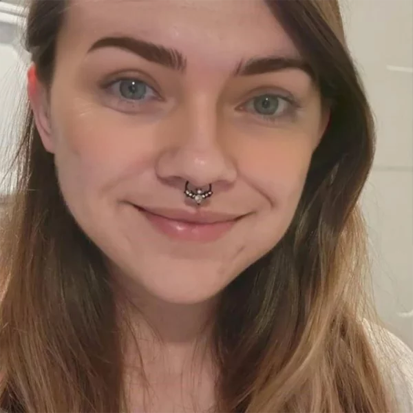 Femme portant un Faux Piercing à Clip au Septum Chauve-Souris Scintillante Femme portant un Faux Piercing à Clip au Septum Chauve-Souris Scintillante.