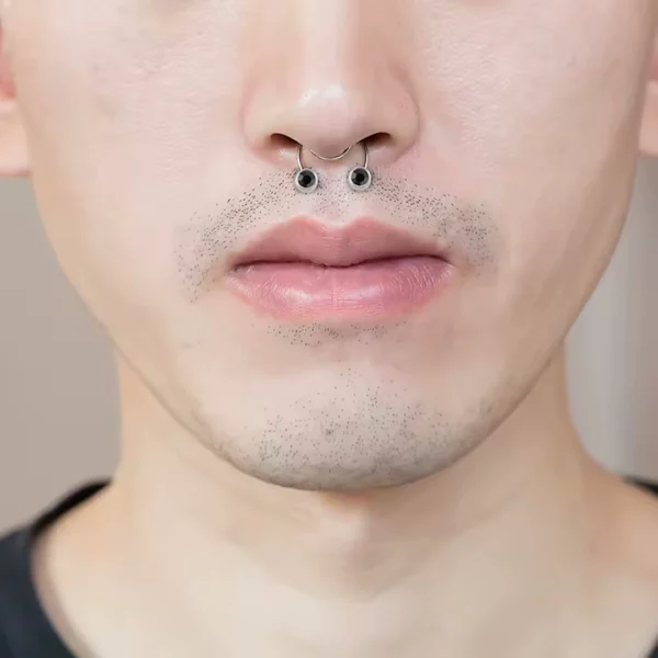Homme avec un Faux Piercing au Septum à Zircons Noirs, Serti Clos Homme avec un Faux Piercing au Septum à Zircons Noirs, Serti Clos.